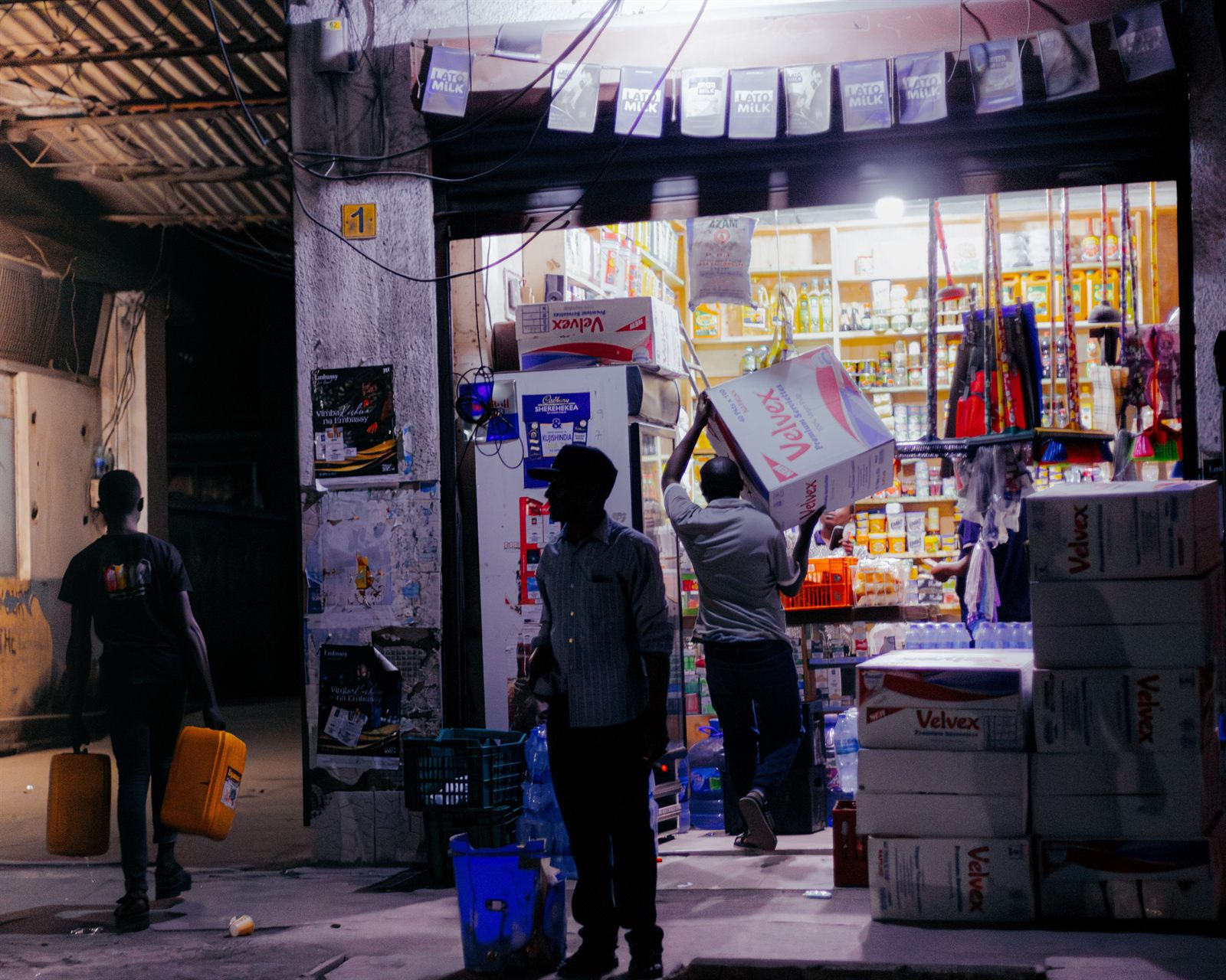 A stocked Ugandan shop with inventory boxes on the shelves